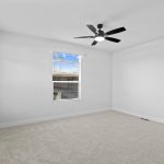 Spacious primary bedroom with ceiling fan for year-round comfort
